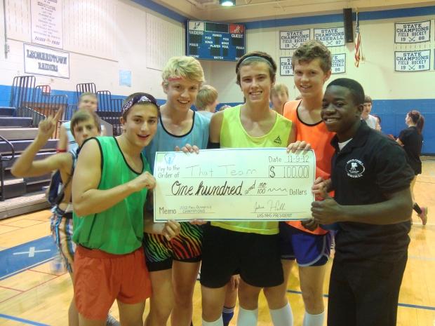 Dane Lemmon, Troy McLaughlin, Jeff Henkel, and Ryan Montgomery (That Team) pose with Mayokun Ojo and their prize after winning the Fall Olympics.