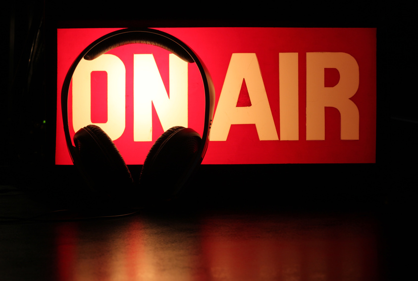 Headphones+silhouette+against+On-Air+sign+symbolising+a+podcast+broadcast.