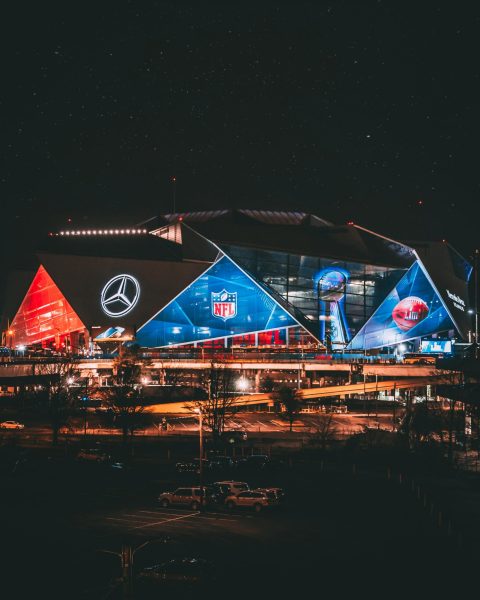 Image of a stadium lit up at night. Photo by Christopher Alvarenga on Unsplash
  